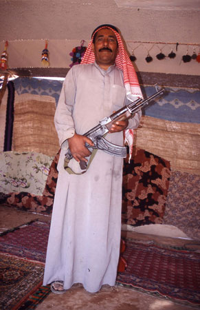 Beduin som stolt visar upp sitt vapen i den syriska öknen.