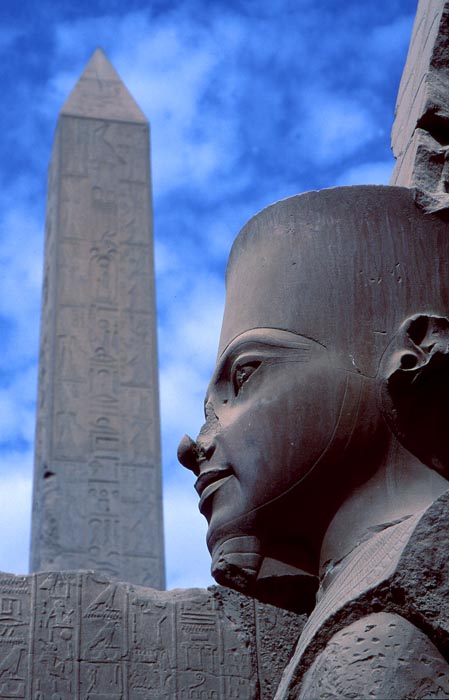 En staty med en obelisk i bakgrunden i Karnaktemplet i Luxor, Egypten.